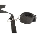 Ερωτικό σετ δεσίματος BDSM κρεβατιού με μαύρες μαλακές χειροπέδες και ρυθμιζόμενους ιμάντες τοποθετημένους κάτω από ένα στρώμα.